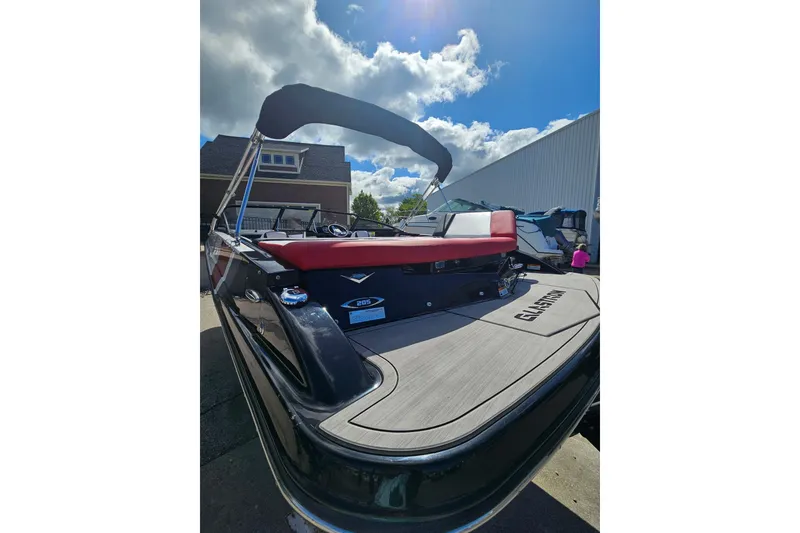 Slide: The Image of 2021 Glastron GTS 205 boat with red seating, docked under a sunny sky. - 5