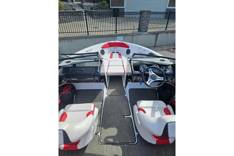 Slide: The Image of 2021 Glastron GTS 205 boat interior with red and white seating, steering wheel, and dashboard. - 7