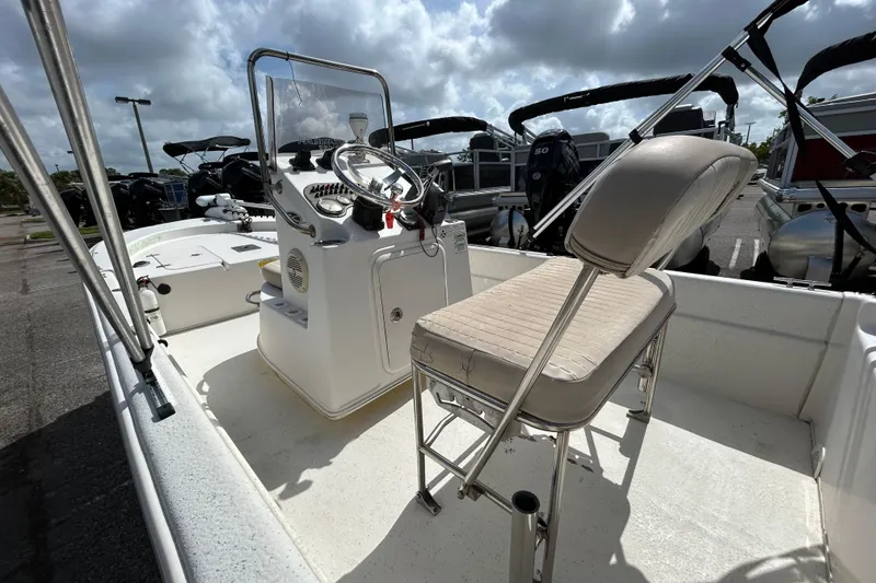 Slide: The Image of 2015 Carolina Skiff JVX18CC boat interior with steering console and seating under cloudy sky. - 10