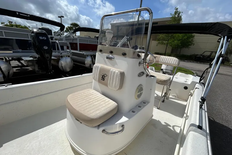 Slide: The Image of 2015 Carolina Skiff JVX18CC boat with center console and seating, parked outdoors. - 12