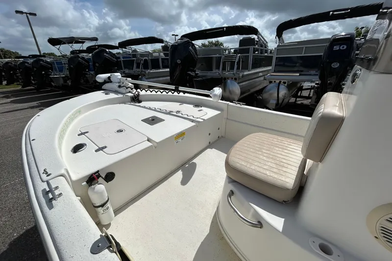 Slide: The Image of 2015 Carolina Skiff JVX18CC boat interior with seating and equipment, parked outdoors. - 13