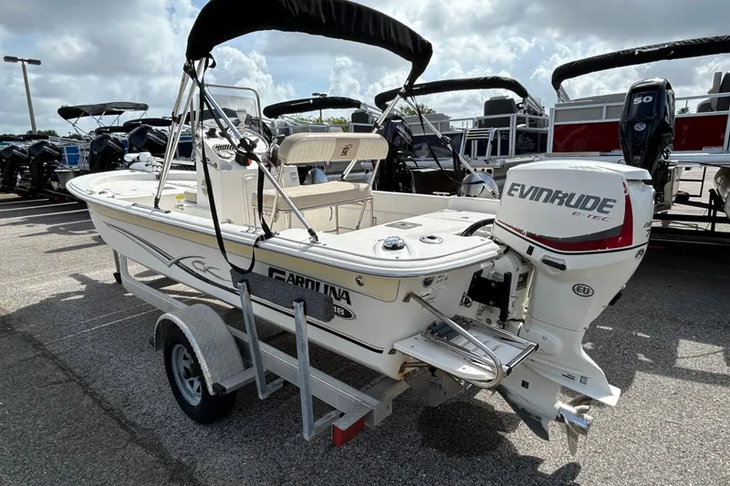 Slide: The Image of 2015 Carolina Skiff JVX18CC boat with Evinrude engine on trailer, parked outdoors. - 2