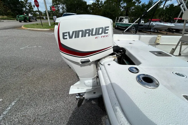 Slide: The Image of 2015 Carolina Skiff JVX18CC with Evinrude E-TEC outboard motor in a parking lot. - 6