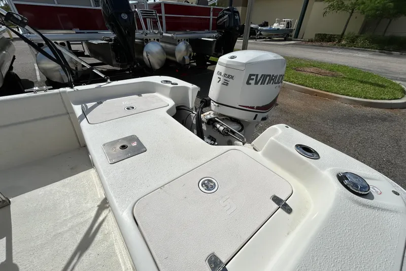 Slide: The Image of 2015 Carolina Skiff JVX18CC boat with Evinrude engine, parked outdoors. - 7