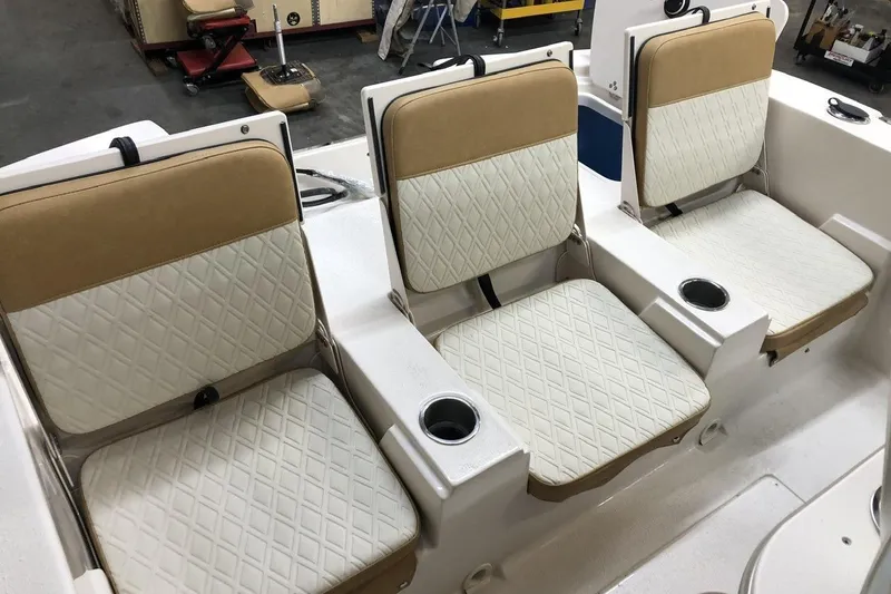 Slide: The Image of 2025 Carolina Skiff 22 Ultra Elite boat seats with diamond-pattern upholstery and cup holders. - 10