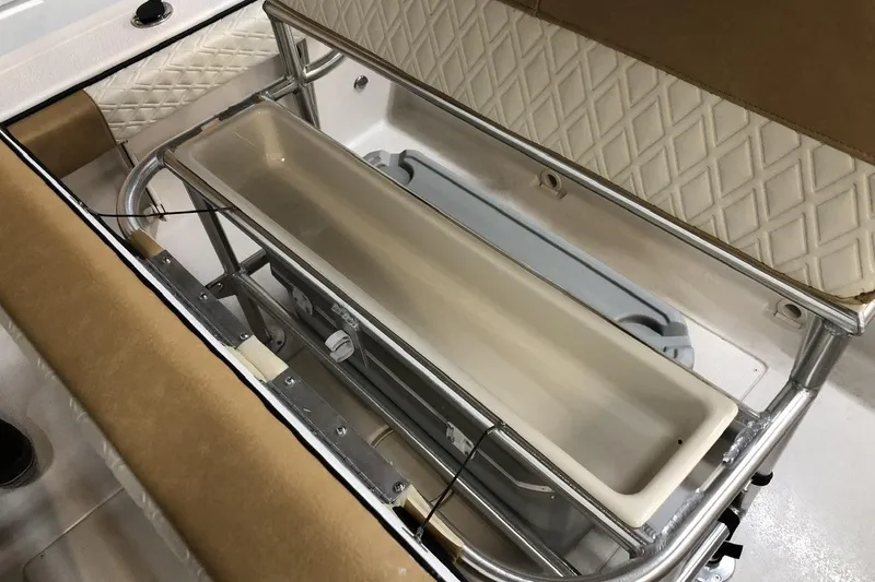 Slide: The Image of 2025 Carolina Skiff 22 Ultra Elite boat interior with storage compartment and cushioned seating. - 12