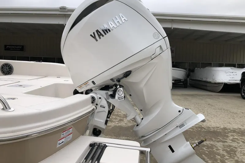 Slide: The Image of 2025 Carolina Skiff 22 Ultra Elite with Yamaha outboard motor in a boatyard. - 2