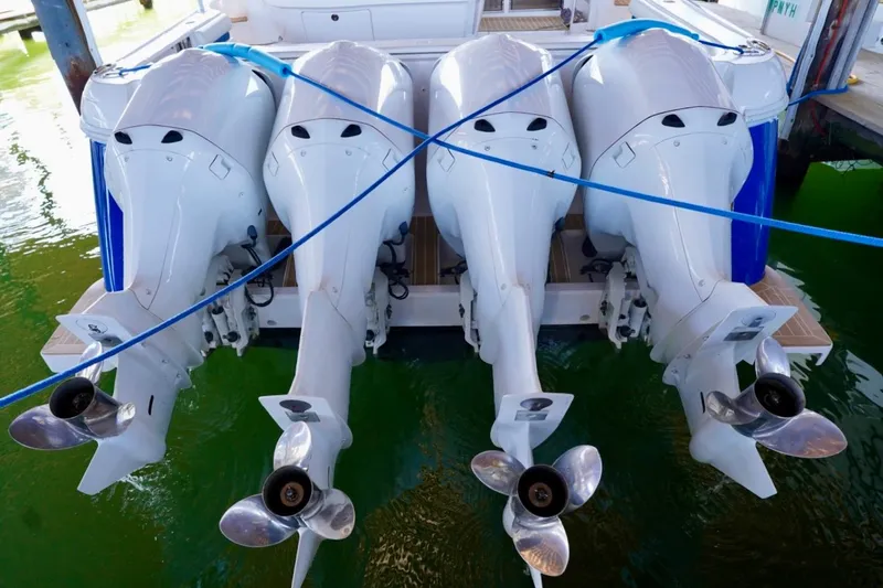 Slide: The Image of Four powerful outboard motors on a 2017 Intrepid 475 Sport Yacht, docked in green water. - 13