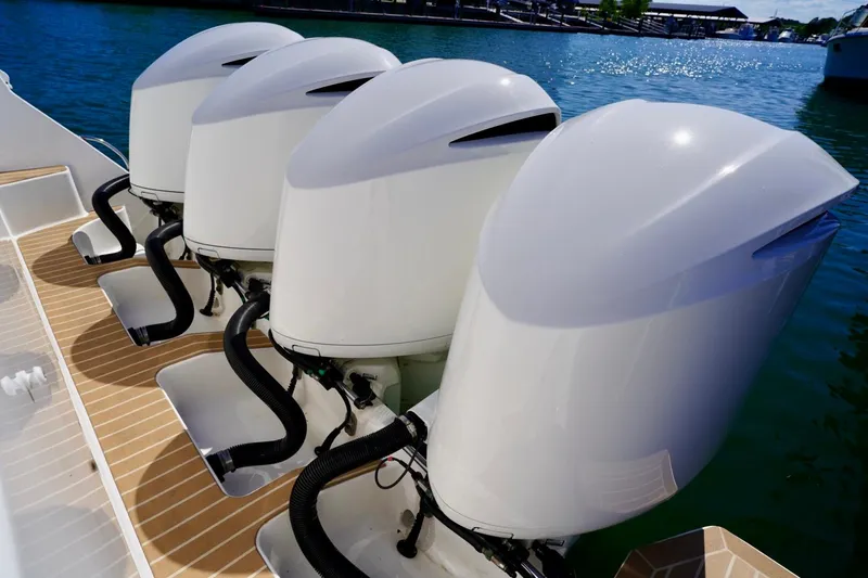 Slide: The Image of Four powerful outboard engines on a 2017 Intrepid 475 Sport Yacht, docked on clear water. - 15