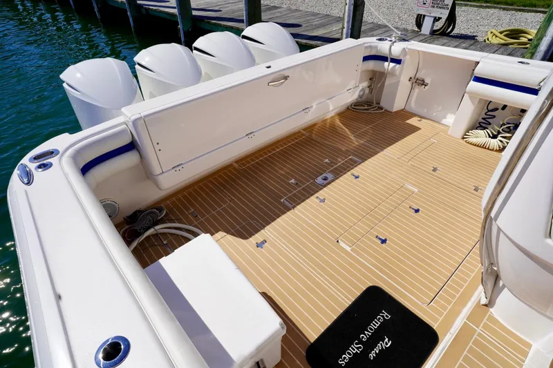 Slide: The Image of 2017 Intrepid 475 Sport Yacht deck with teak flooring and outboard engines. - 16