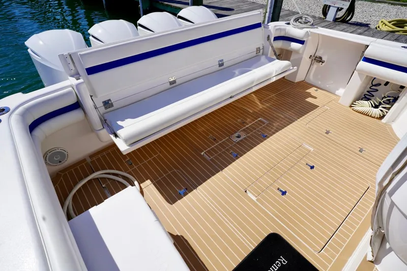 Slide: The Image of 2017 Intrepid 475 Sport Yacht deck with seating and storage, docked by the water. - 17