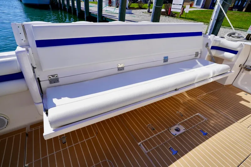 Slide: The Image of 2017 Intrepid 475 Sport Yacht with white seating and teak deck, docked by the water. - 19