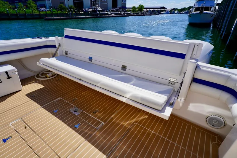 Slide: The Image of 2017 Intrepid 475 Sport Yacht with foldable seating on teak deck by the water. - 20