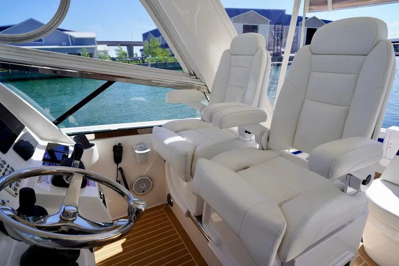 Slide: The Image of Luxury helm seating on 2017 Intrepid 475 Sport Yacht with modern controls and steering wheel. - 42