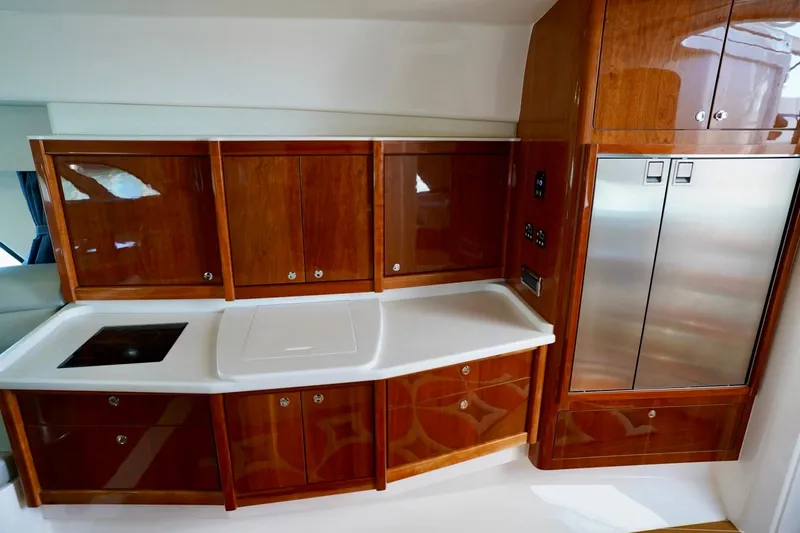 Slide: The Image of Luxurious 2017 Intrepid 475 Sport Yacht kitchen with sleek wood cabinetry and modern appliances. - 57