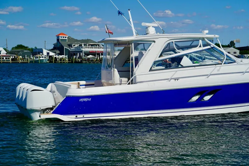 Slide: The Image of 2017 Intrepid 475 Sport Yacht cruising on a sunny day near a coastal town. - 6
