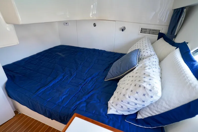 Slide: The Image of Cozy cabin bed with blue bedding in 2017 Intrepid 475 Sport Yacht. - 64