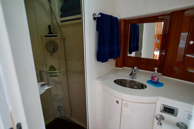 Slide: The Image of Luxurious bathroom in 2017 Intrepid 475 Sport Yacht with modern fixtures and elegant wood accents. - 69
