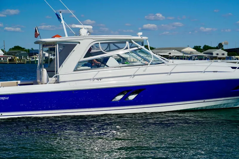 Slide: The Image of 2017 Intrepid 475 Sport Yacht on water, featuring sleek blue and white design. - 7
