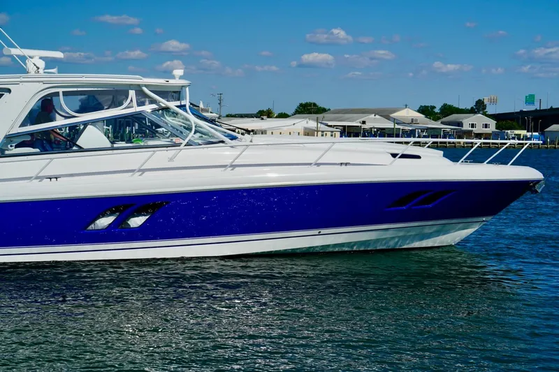 Slide: The Image of 2017 Intrepid 475 Sport Yacht cruising on calm waters under a clear blue sky. - 8