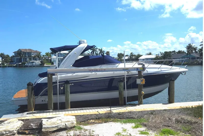 Slide: The Image of 2005 Formula 37 Performance Cruiser docked by waterfront homes under clear blue sky. - 37