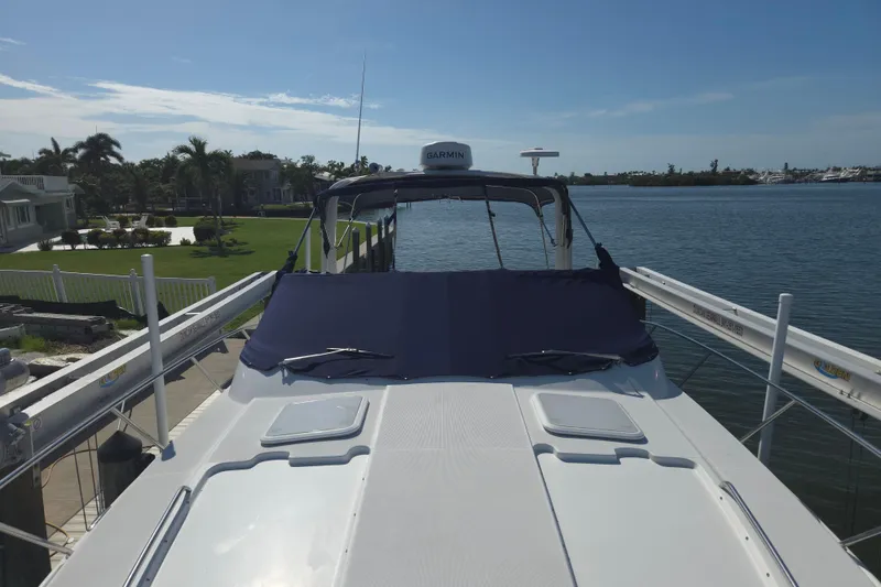 Slide: The Image of 2005 Formula 37 Performance Cruiser docked by waterfront homes, featuring a covered deck. - 4