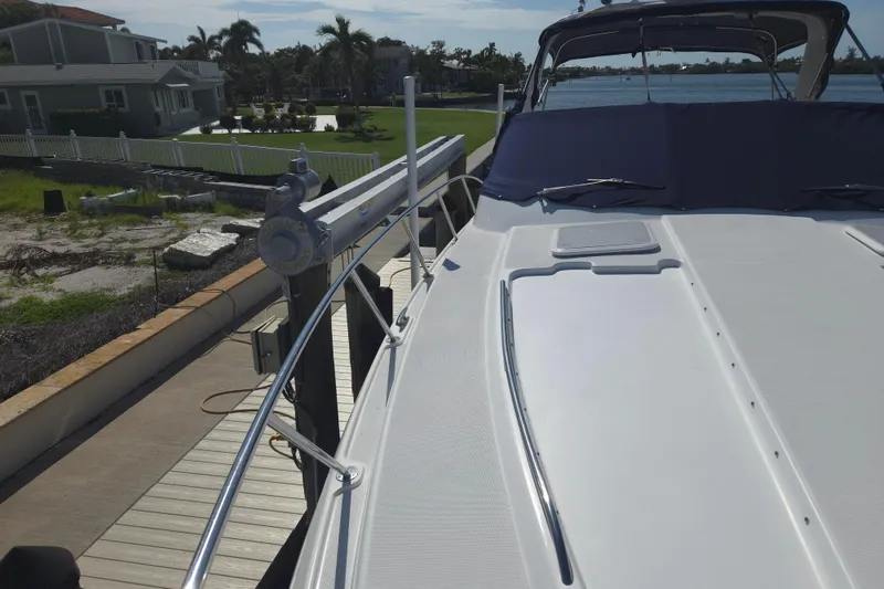 Slide: The Image of 2005 Formula 37 Performance Cruiser docked near waterfront homes and palm trees. - 6