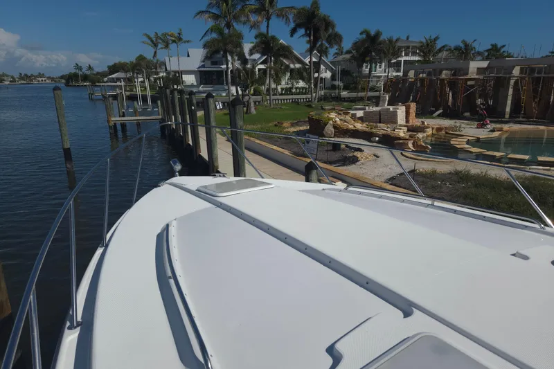 Slide: The Image of 2005 Formula 37 Performance Cruiser docked by waterfront homes and palm trees. - 8