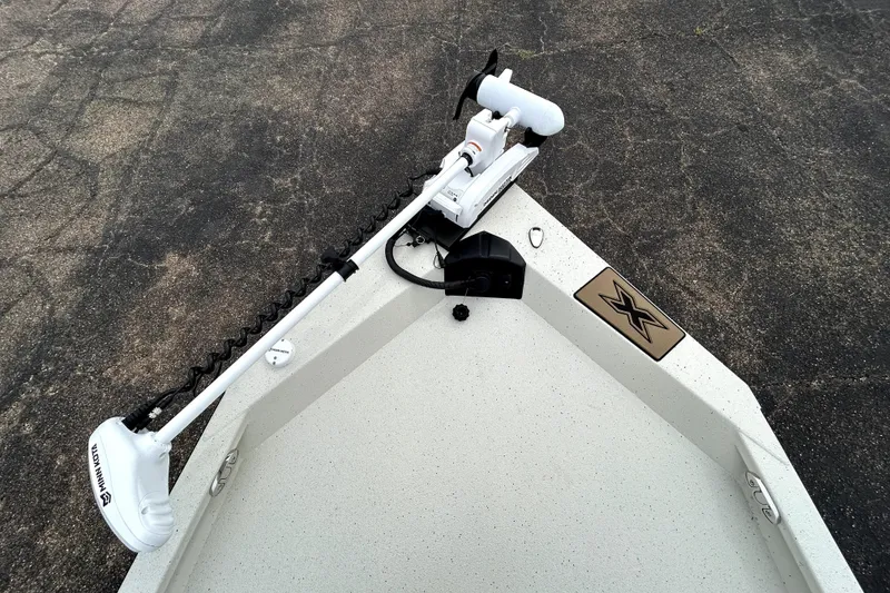 Slide: The Image of 2026 Xpress H20B Bay boat with Minn Kota trolling motor on pavement. - 13