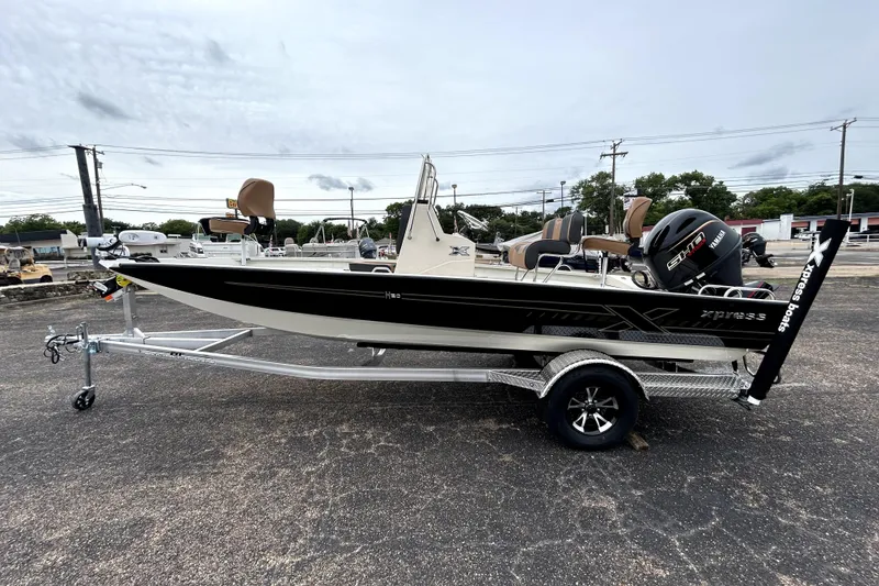 Slide: The Image of 2026 Xpress H20B Bay boat on trailer, featuring Yamaha engine, parked outdoors. - 4