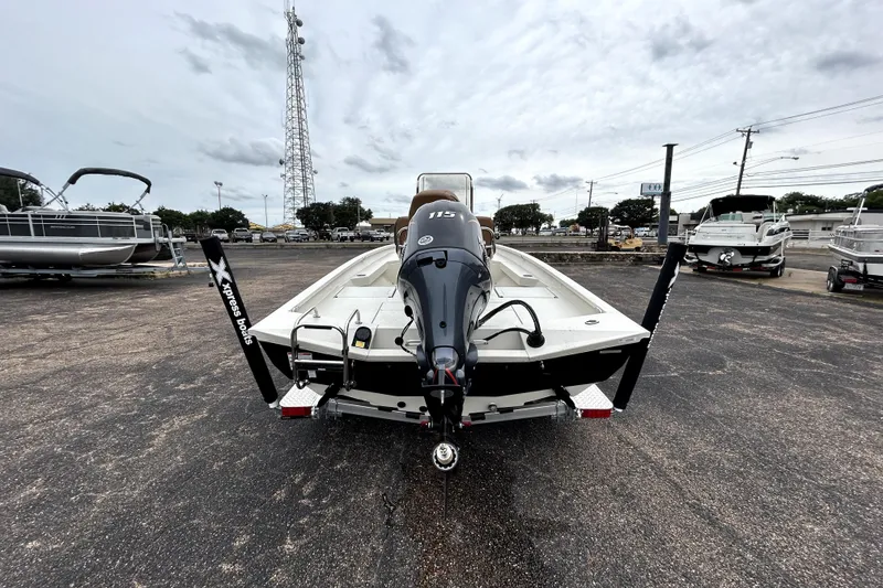 Slide: The Image of 2026 Xpress H20B Bay boat with outboard motor in a parking lot. - 8