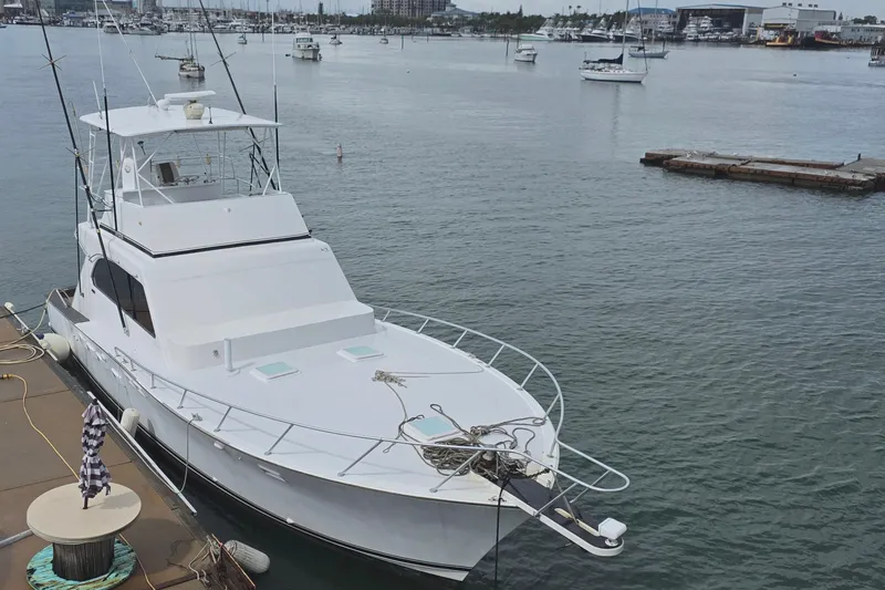 The Image of 1979 Post 46 Convertible yacht docked in a marina with calm waters and distant boats. - 1