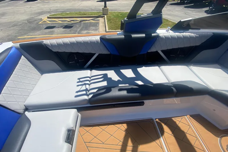 Slide: The Image of 2021 Tigé Z3 boat interior with blue and white seating, parked in a lot. - 17