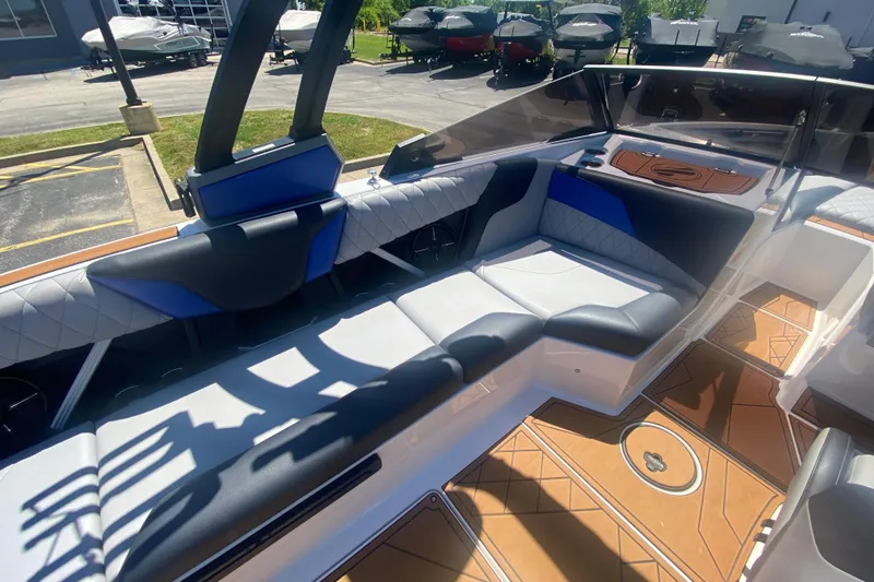Slide: The Image of 2021 Tigé Z3 boat interior with blue and white seating, wood-patterned flooring. - 18