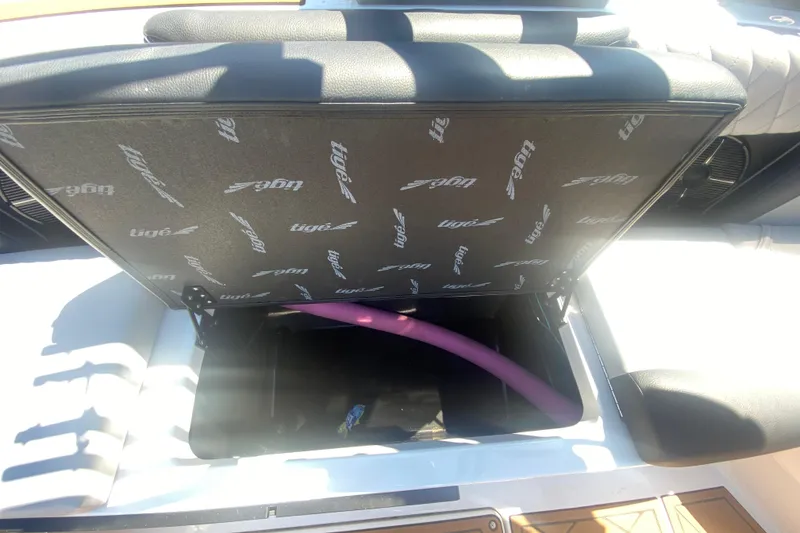 Slide: The Image of Open storage compartment in 2021 Tigé Z3 boat with visible pink pool noodle. - 26