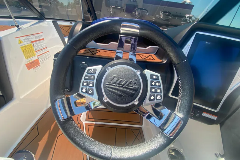 Slide: The Image of Steering wheel of a 2021 Tigé Z3 boat with control buttons and touchscreen display. - 28