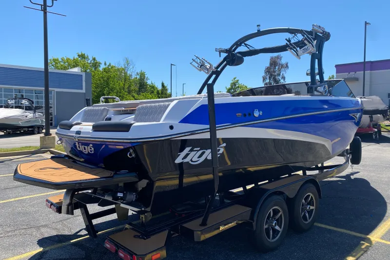 Slide: The Image of 2021 Tigé Z3 boat on trailer, blue and white design, parked outdoors. - 4
