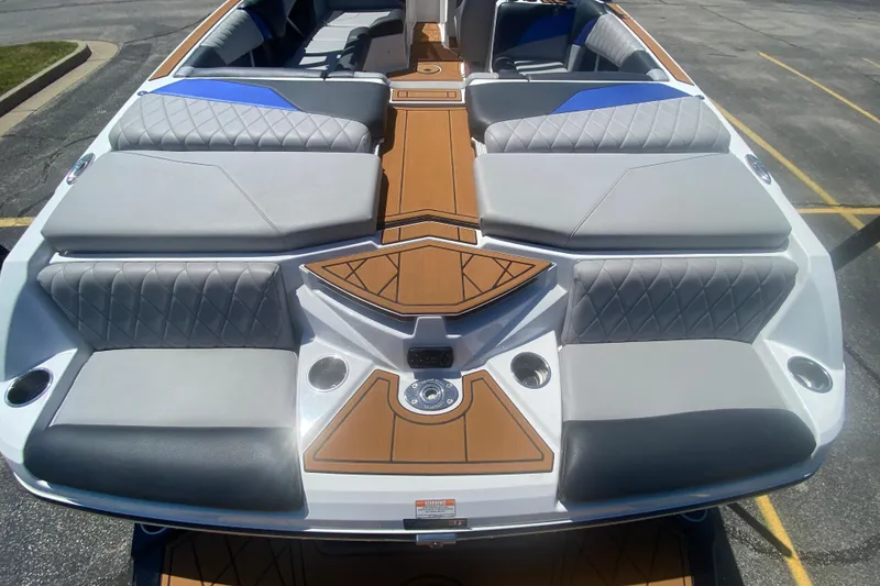 Slide: The Image of 2021 Tigé Z3 boat interior with gray and blue seating, wood accents, and cup holders. - 7