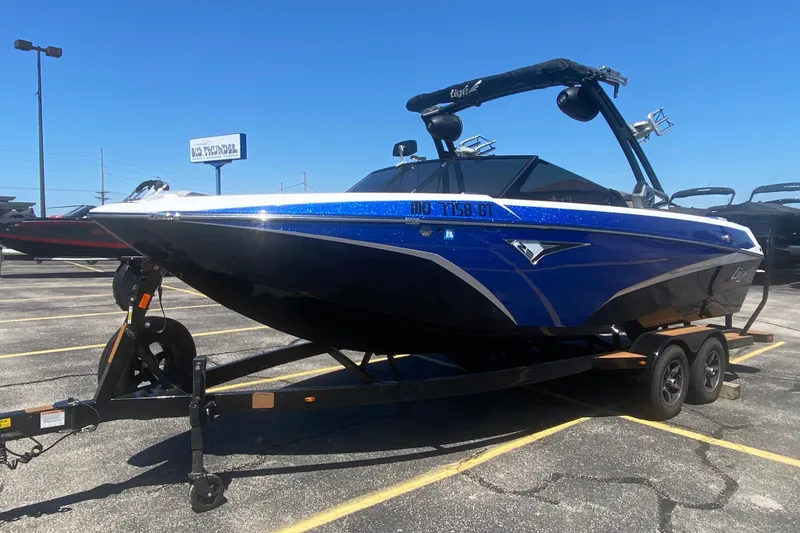 Slide: The Image of 2021 Tigé Z3 boat on trailer in parking lot, blue and black design. - 9