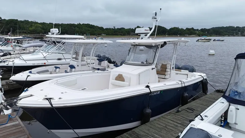 The Image of 2015 Edgewater 280CC boat docked at marina, surrounded by other vessels. - 0