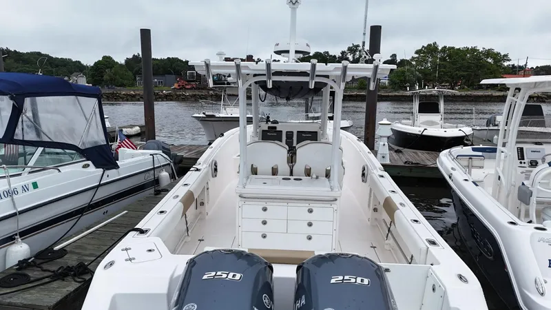 Slide: The Image of 2015 Edgewater 280CC boat docked, featuring dual 250 engines, surrounded by other boats. - 10