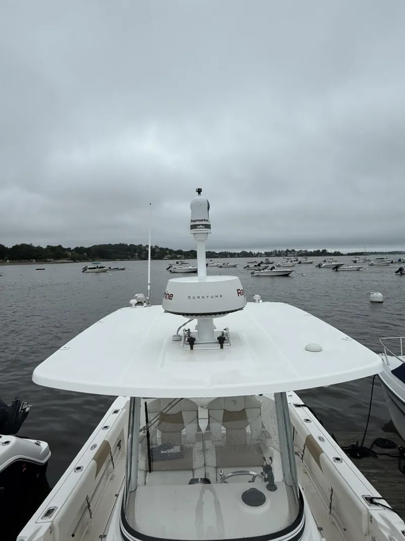 Slide: The Image of 2015 Edgewater 280CC boat with radar, docked on a cloudy day. - 15