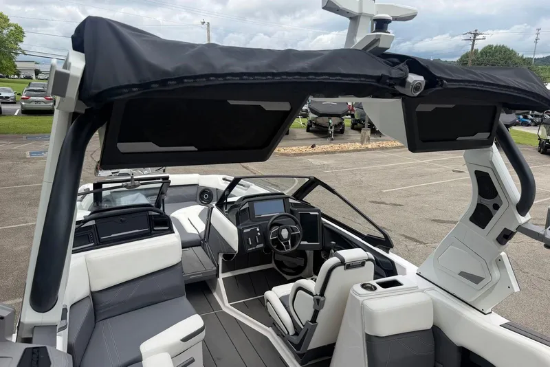 Slide: The Image of 2024 Supra SE 550 boat interior with modern dashboard and seating in a parking lot. - 11