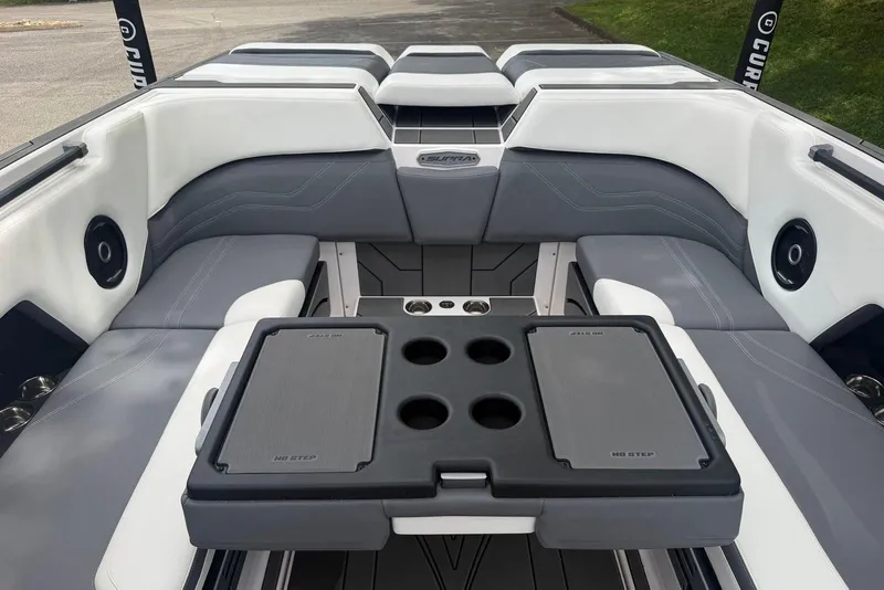 Slide: The Image of 2024 Supra SE 550 boat interior with gray and white seating, cup holders, and speakers. - 14