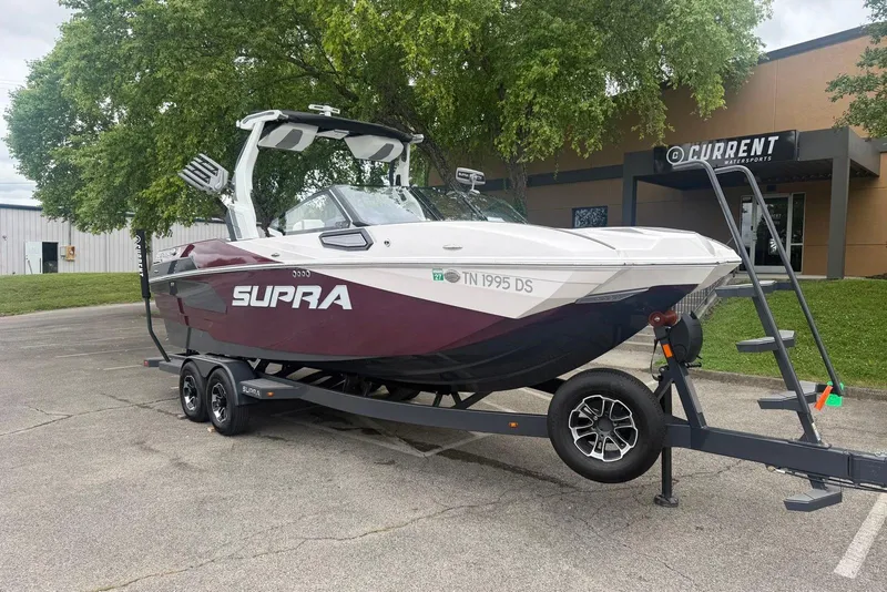 Slide: The Image of 2024 Supra SE 550 boat on trailer, parked outside Current Watersports building. - 4