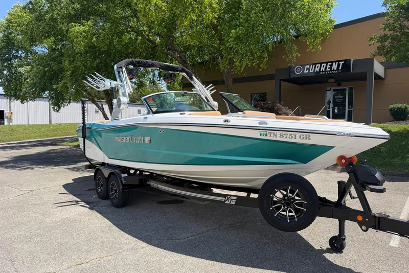 Slide: The Image of 2020 MasterCraft XT25 boat on trailer outside Current Watersports building. - 1