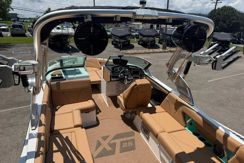 Slide: The Image of 2020 MasterCraft XT25 boat interior with tan seating and advanced audio system. - 11