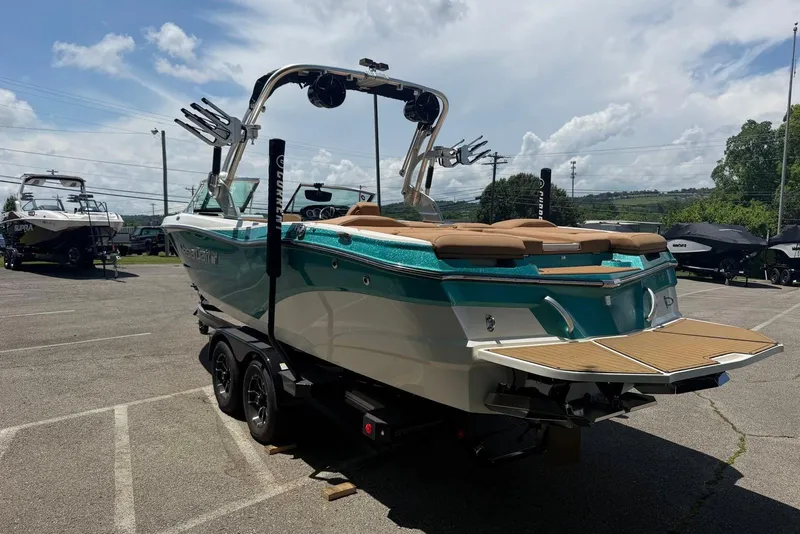 Slide: The Image of 2020 MasterCraft XT25 boat on trailer in parking lot under cloudy sky. - 2
