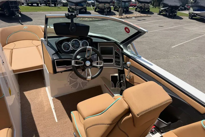 Slide: The Image of Interior view of 2020 MasterCraft XT25 boat with tan seating and modern dashboard. - 7