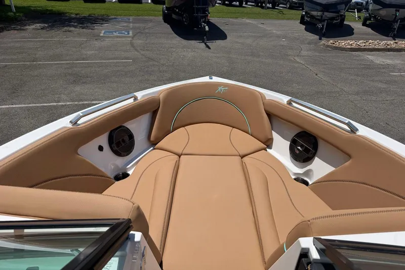 Slide: The Image of 2020 MasterCraft XT25 boat interior with tan seating and built-in speakers. - 9